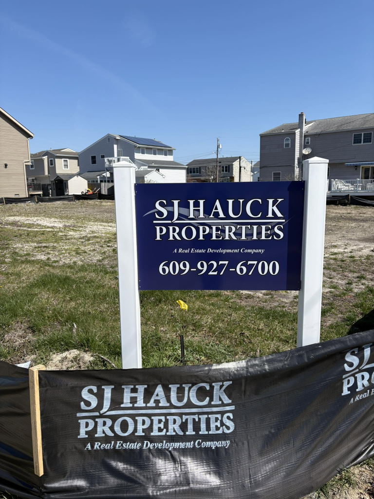 SJ Hauck Properties sign at an active real estate development site