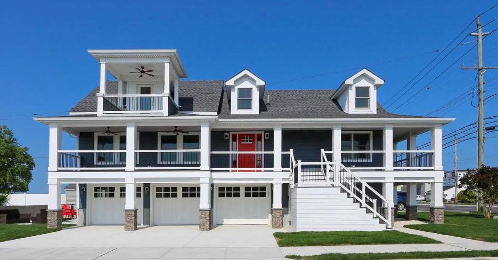 Completed SJ Hauck Properties residential home — navy blue coastal design with wrap-around porch and rooftop deck